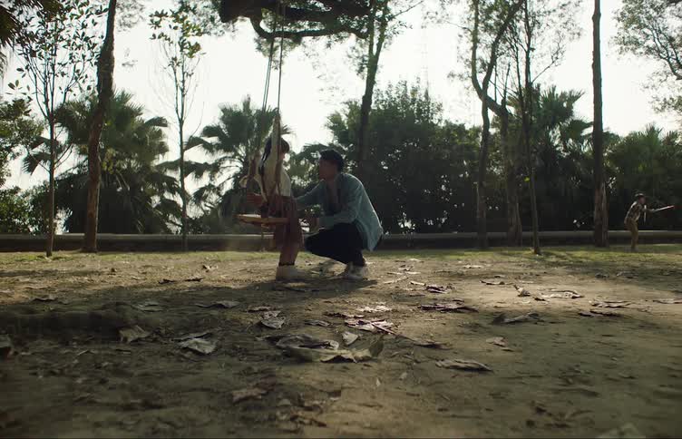 A man pushes his daughter on the swing