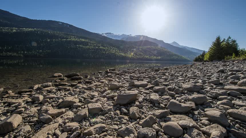 The sun shines down on a river in the mountains