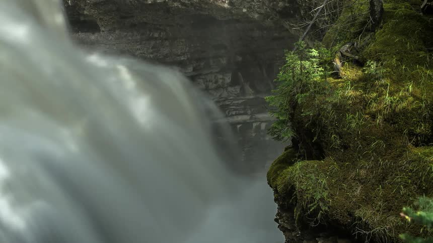 Time lapse of a waterfall pouring water into a stream