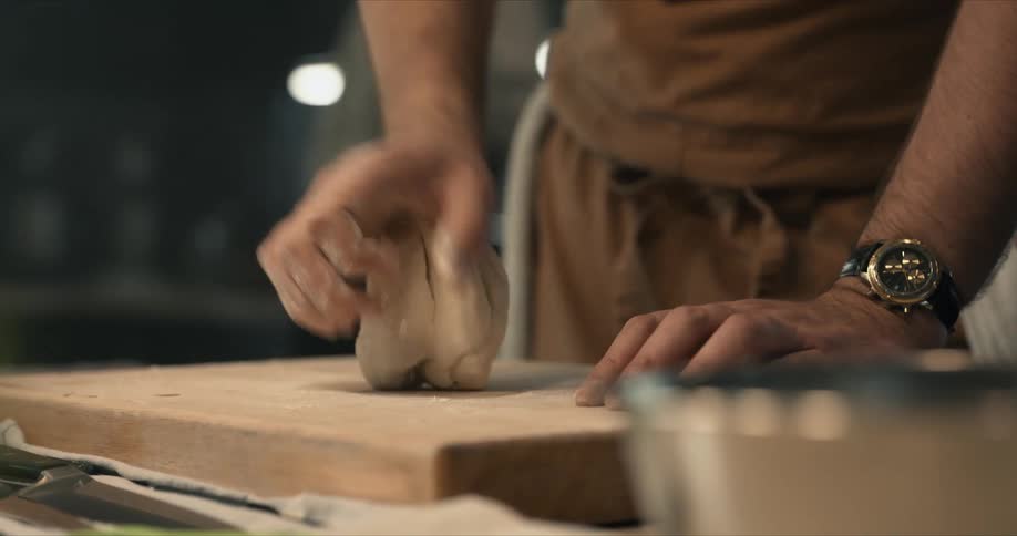 A man rolling dough on a cutting board