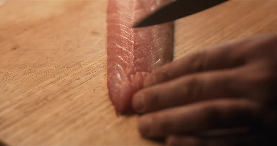 Person preparing raw fish