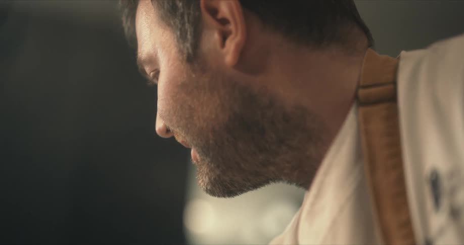 Happy chef wearing an apron cooking in the kitchen at home