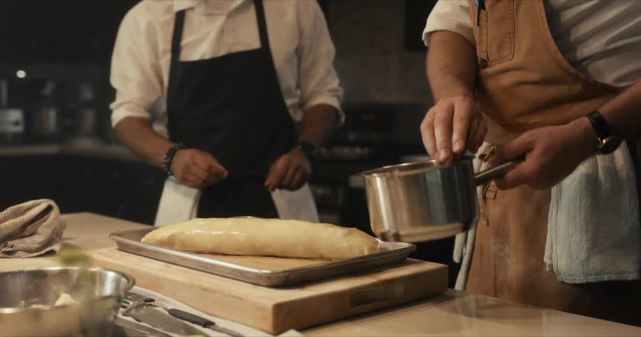Two chefs are preparing food in the kitchen