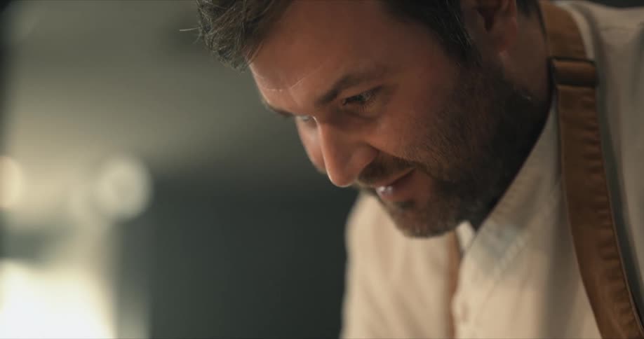 A chef is leaning forward