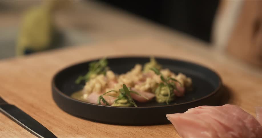 A person places parsley on a dish