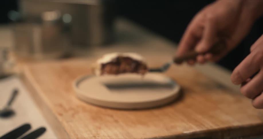 A man uses a spatula to lift food from a pan and places it on a plate