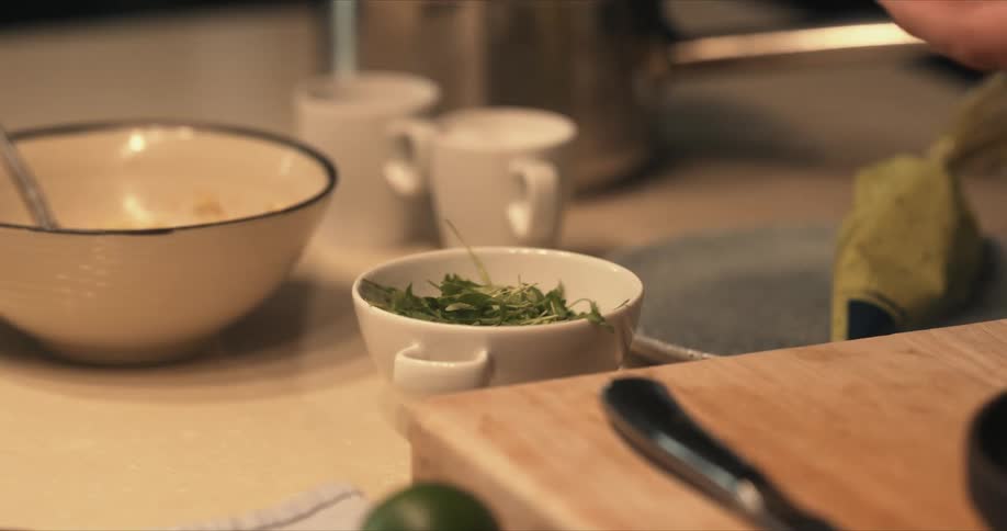 A person lifts parsley from the cup