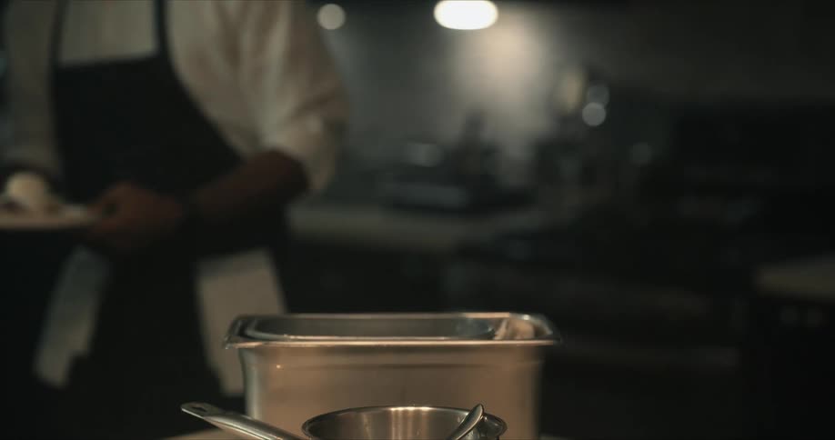 A man hands a plate with a pastry on it to another man who takes it and walks away