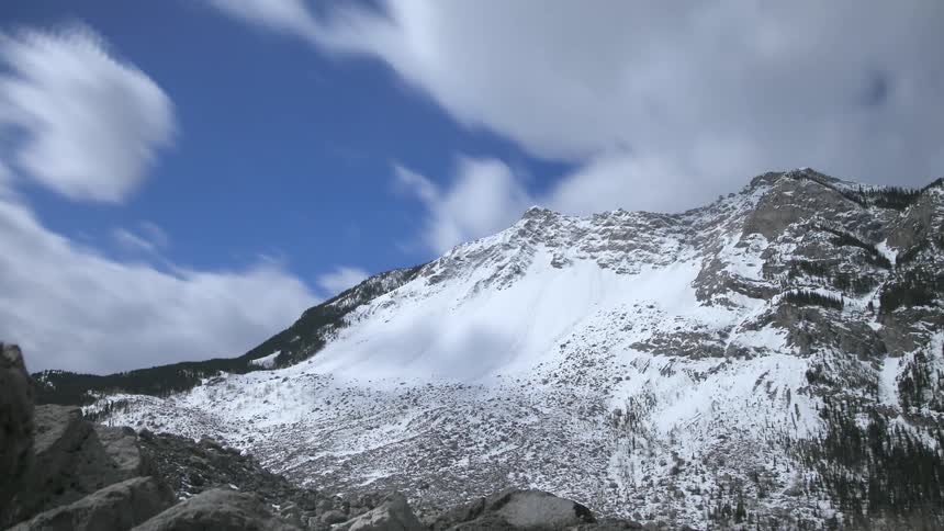 Clouds passing over a snow covered mountain