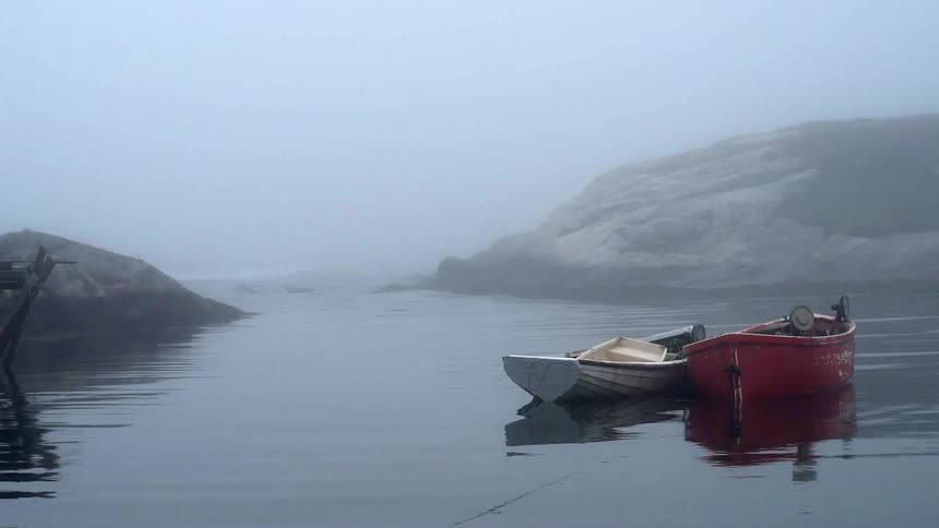 Two boats are docked together in a lake on a cloudy day
