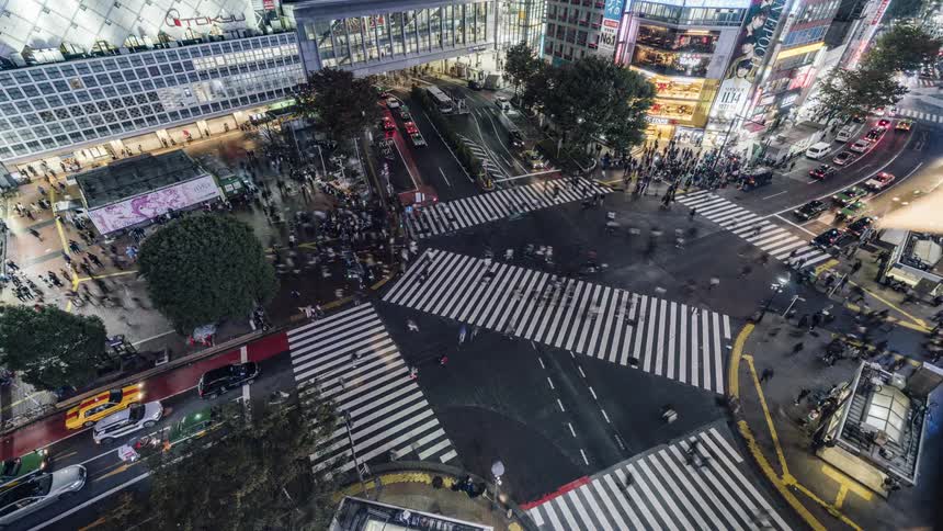 Pedestrians and vehicles move through busy intersection