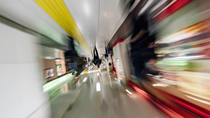 People are walking by stores and businesses in a mall