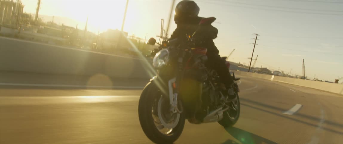 A motorcycle drives around a curve in the road