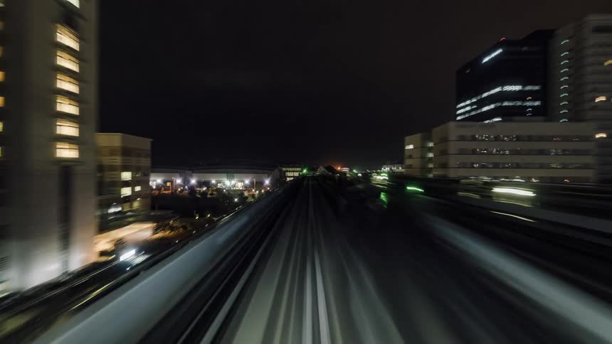 An elevated railway through a metropolis at night