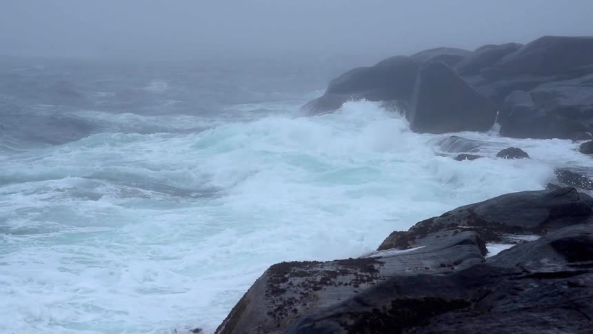 Ocean waves break and splash against the rocks