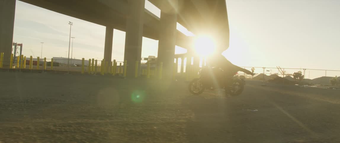 A person gets on their motorcycle