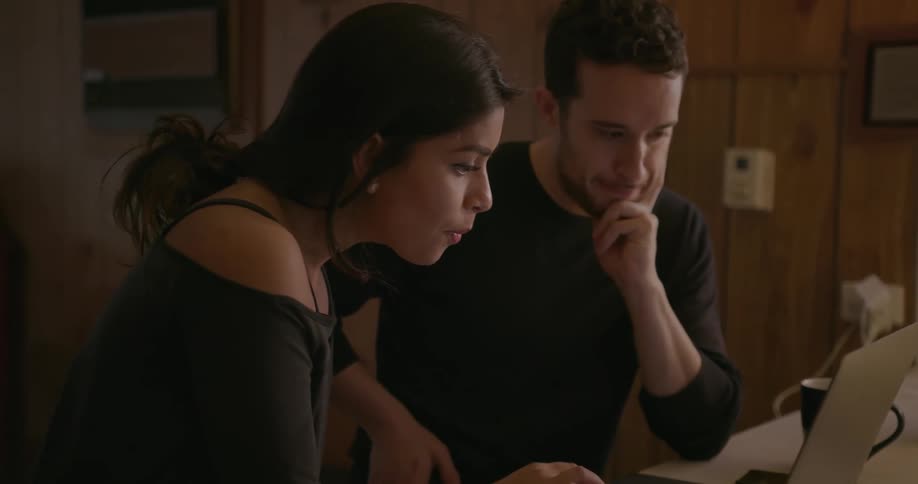 A couple works on a laptop
