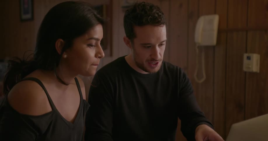 Couple talking while looking at a laptop and drinking tea