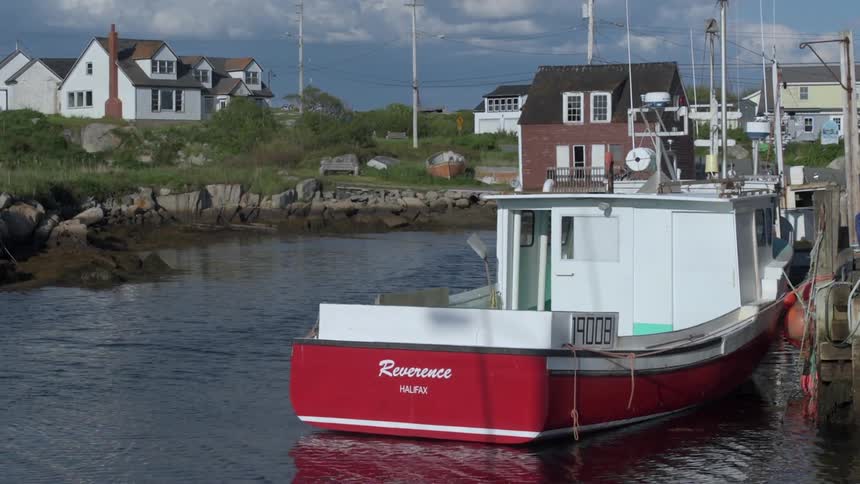 A red and white boat is docked near a pier