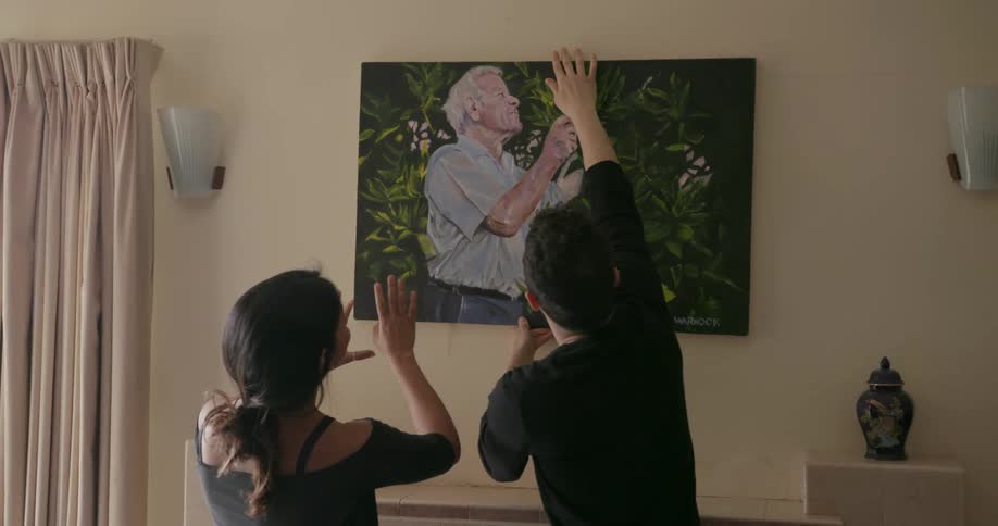 A couple hangs a painted portrait
