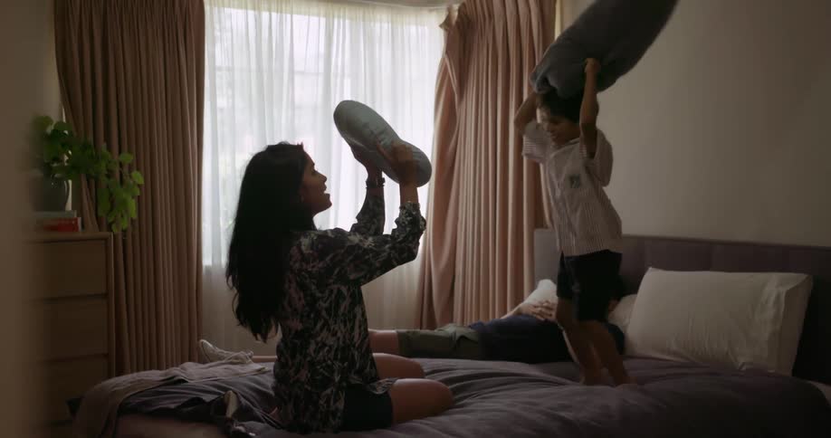 A mother and child have a pillow fight