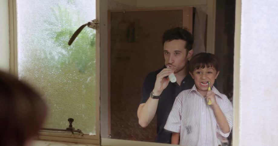 A father and son brush their teeth together
