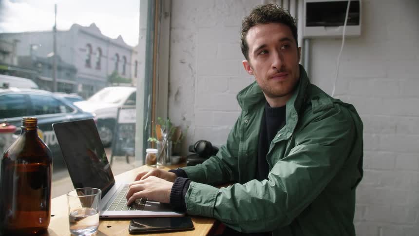 A man uses a laptop at a coffee shop