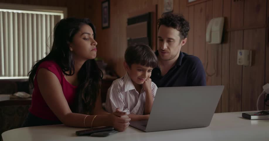 A young family looks at a laptop