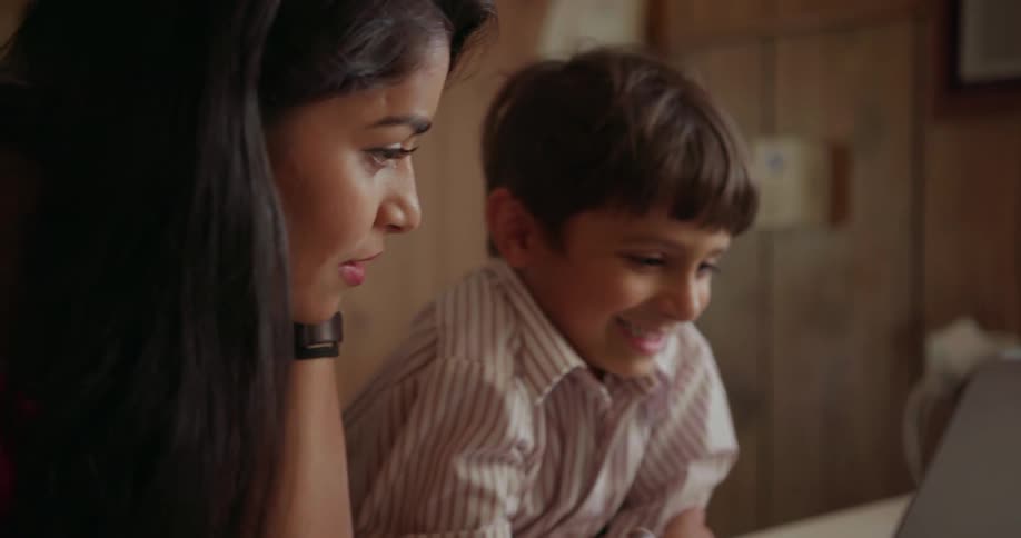 A woman and young child use a laptop together
