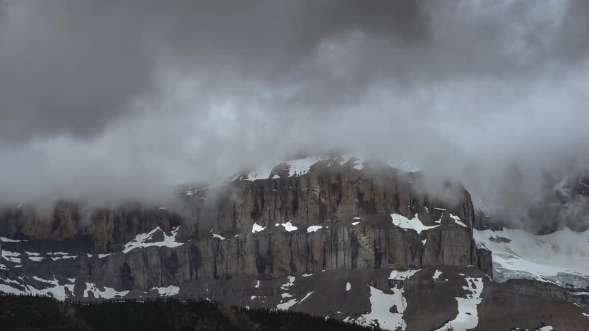 Clouds float over a snowy ridge