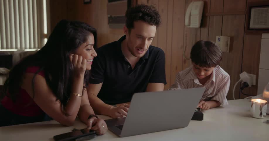 A man, woman and young boy use a laptop