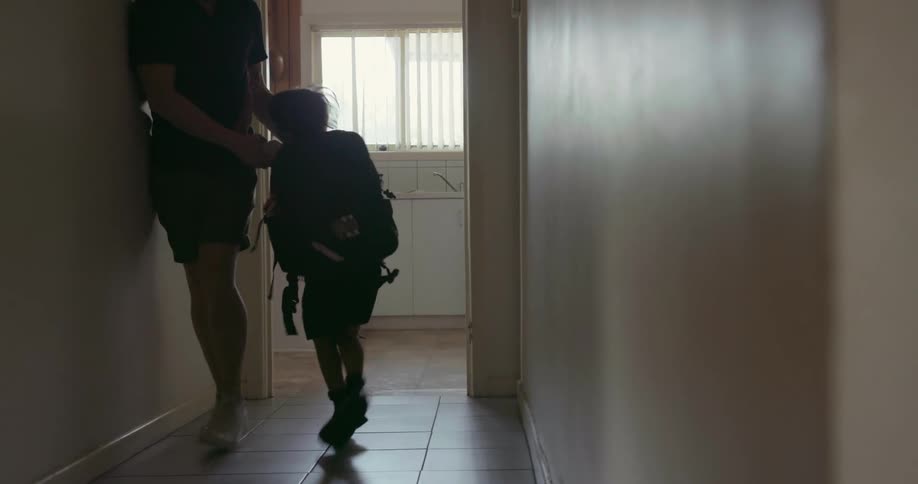 A father helps his son get ready for school