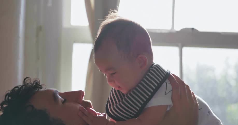 A man is playing with a small baby