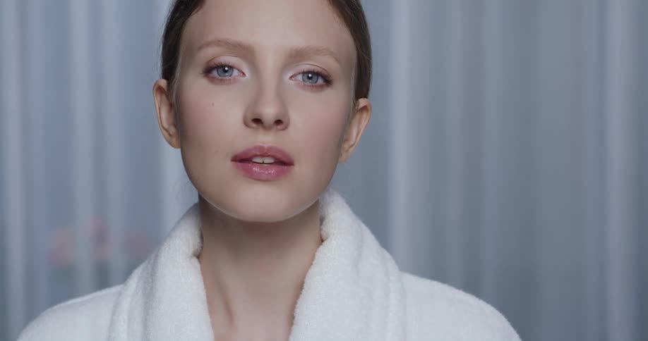 A female model is posing for the camera and wearing makeup