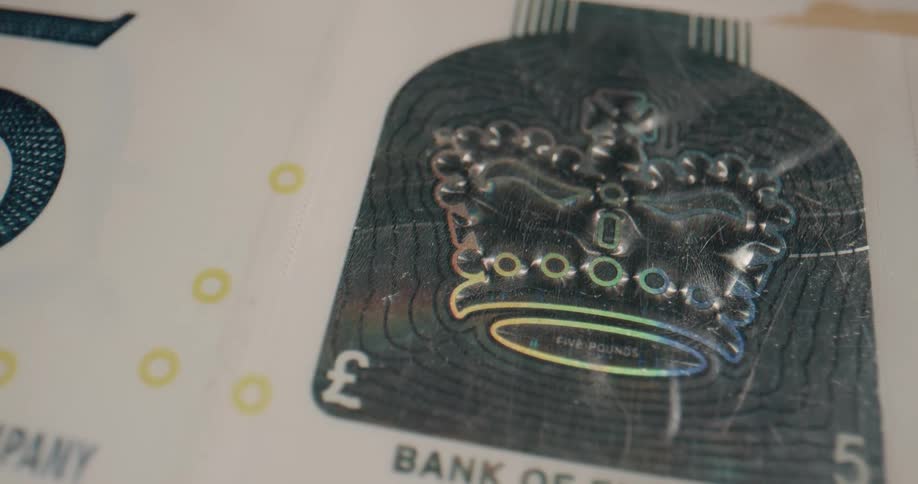 Crown symbol on 5 pound english paper currency changes colors depending on angle