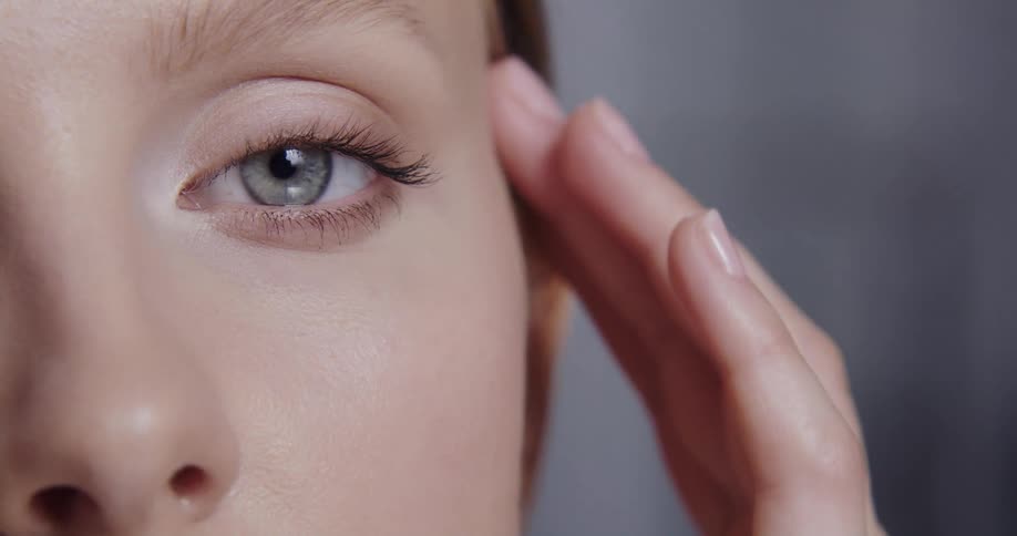 A woman rubs her cheeks