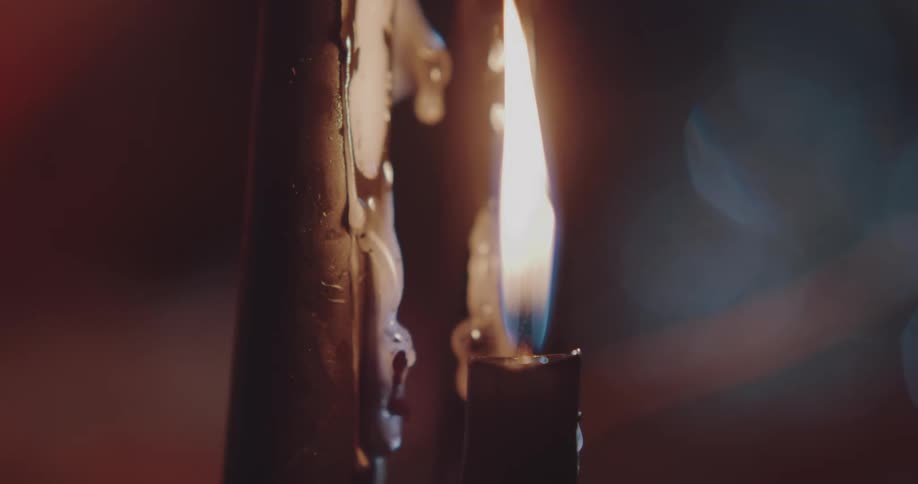 Wax drips down a lit pillar candle