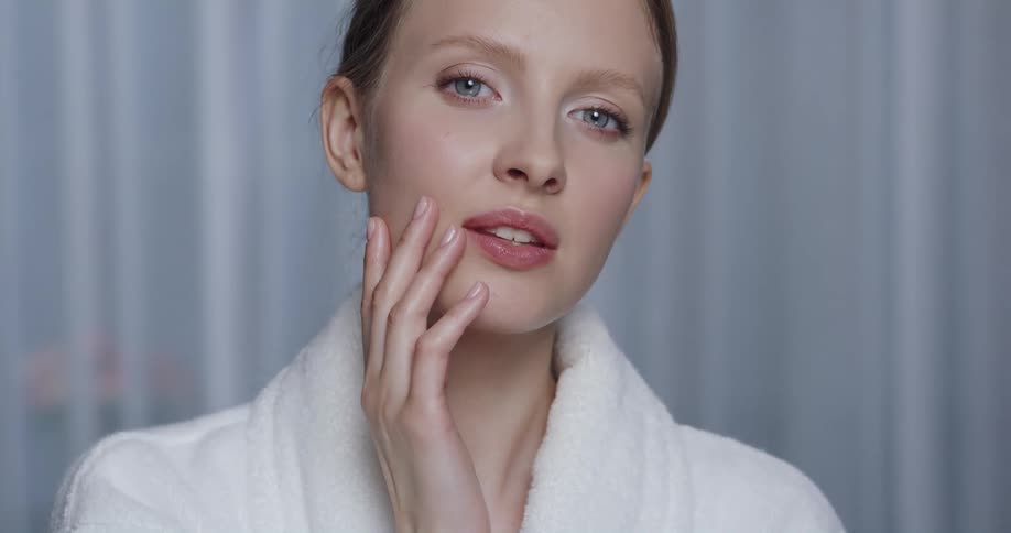 A woman is posing while touching her face