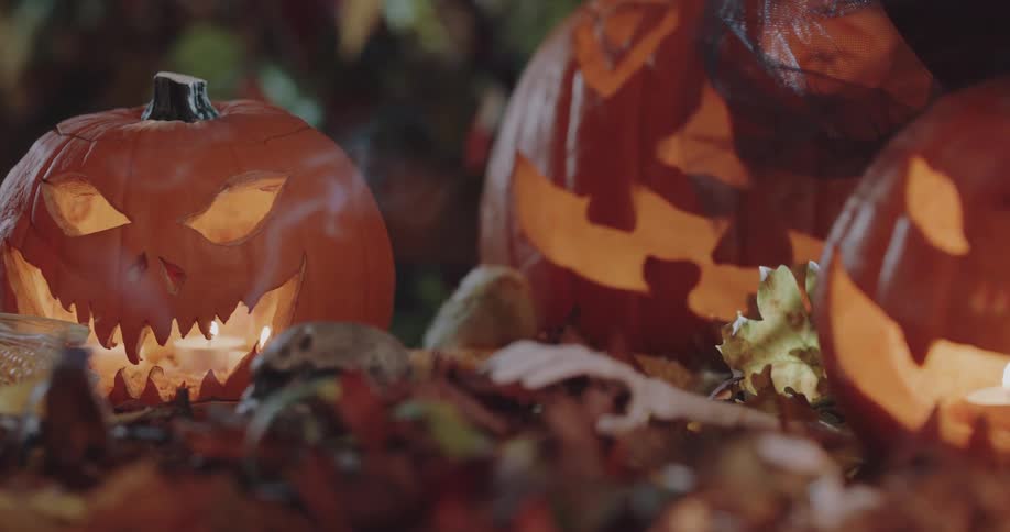 A group of glowing jack o lanterns on surface outdoors at night