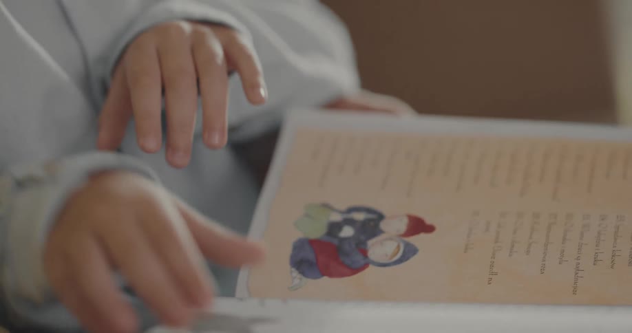 A child is reading pages in a story book