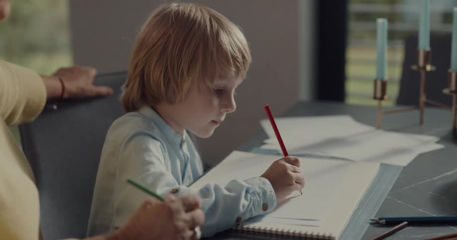 A grandmother draws with her grandson