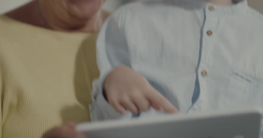 Grandmother and grandson playing a videogame on a tablet together