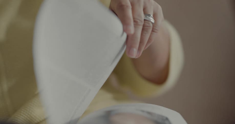 A woman is sitting and reading a book indoors