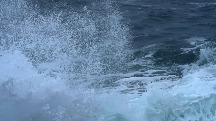 The water is rough below with water splashing all over