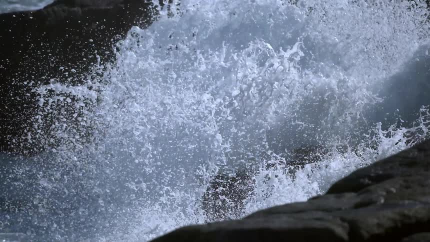 Water is rushing and crashing against rocks