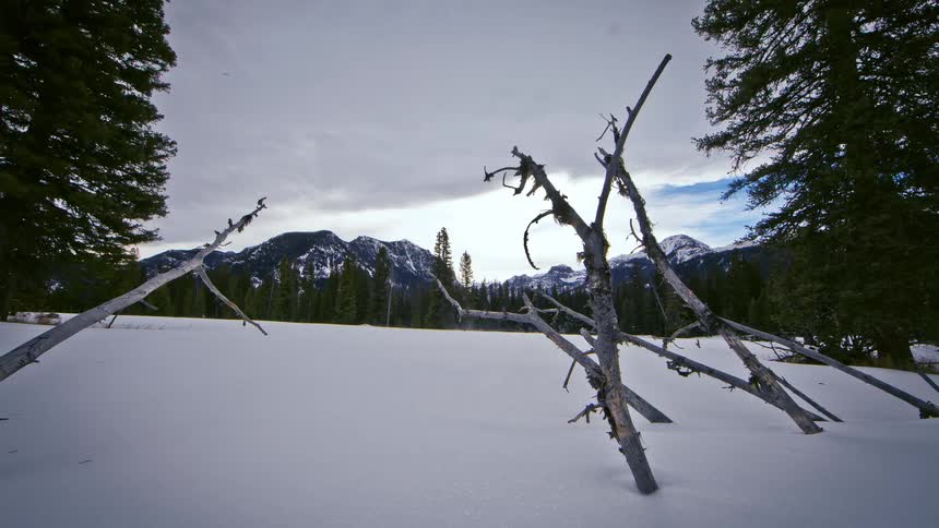 Time lapse of a snow covered field leading to a mountain