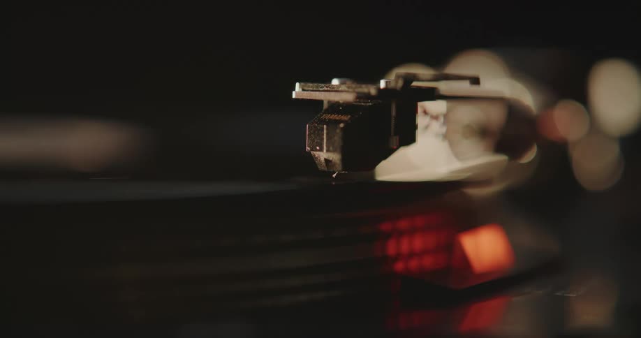 A needle sets down on a record on an old record player