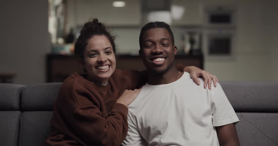 A couple laugh on the couch together