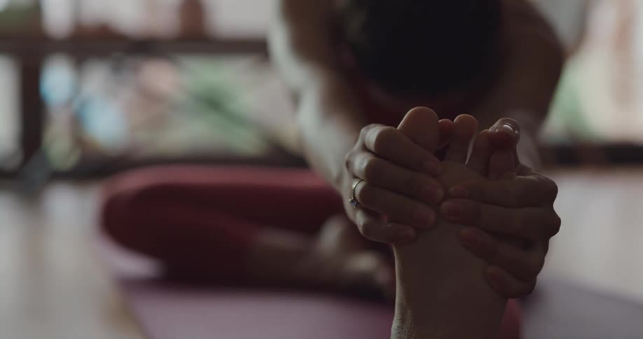 Woman is sitting on a mat and doing yoga