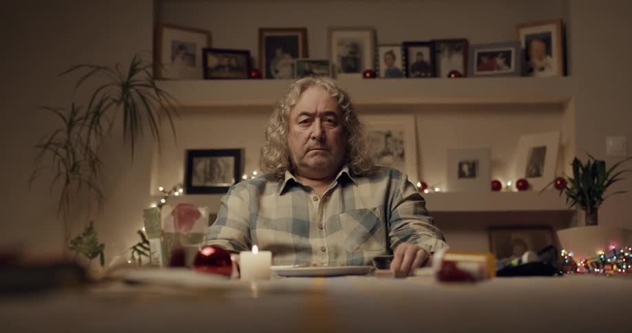 A man is sitting at a kitchen table and eating dinner